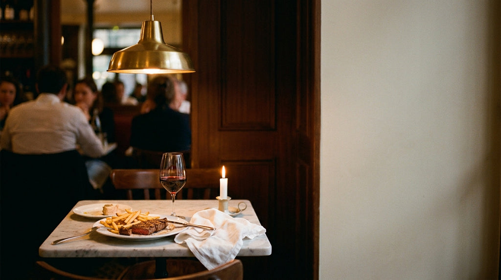 French bistro dinner table with steak frites and red wine