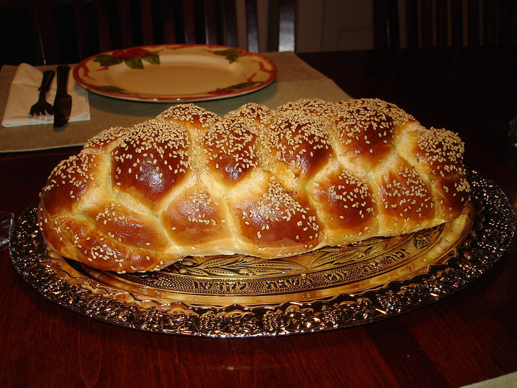 Freshly braided challah on a silver platter — the centerpiece of a kosher table