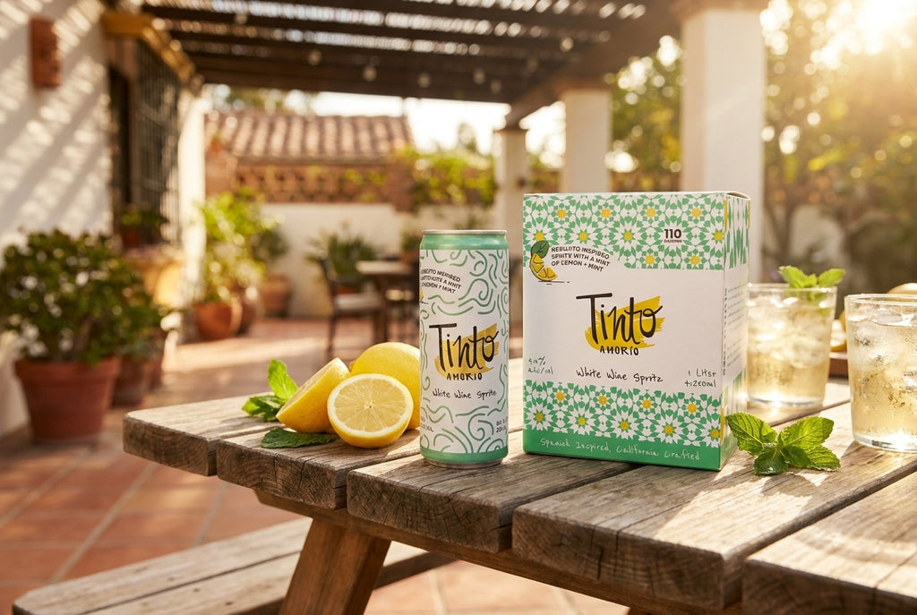 Rebujito White Wine Spritz can and box on a backyard picnic table with lemons and mint