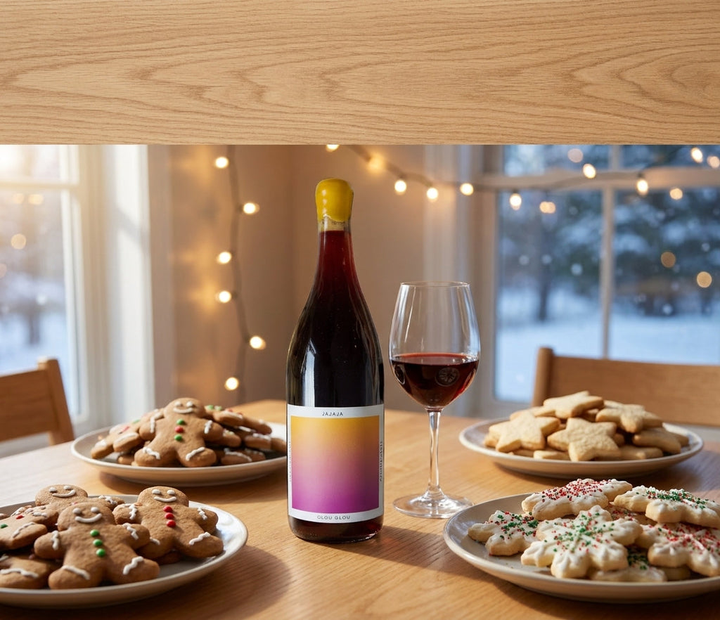 Jajaja glou glou red wine bottle on a holiday cookie exchange table with gingerbread and sugar cookies