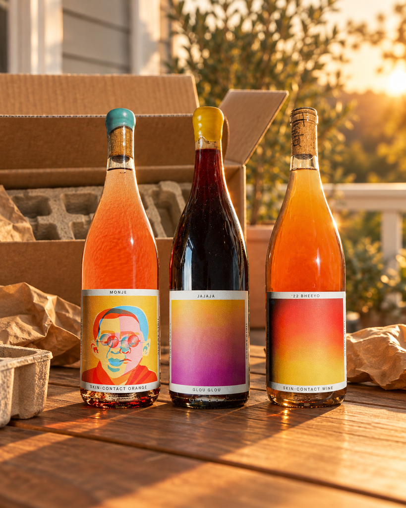 Tinto Amorio Natural Wine Sampler (Monje, Jajaja, '22 Bheeyo) beside an open shipping carton on a golden-hour porch table