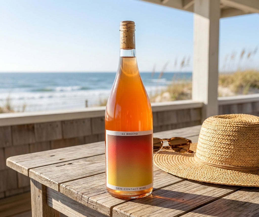 Bheeyo skin-contact orange wine bottle on a sunny beach house porch table